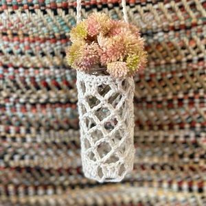 Upcycled glass jar with crocheted cotton hanger.